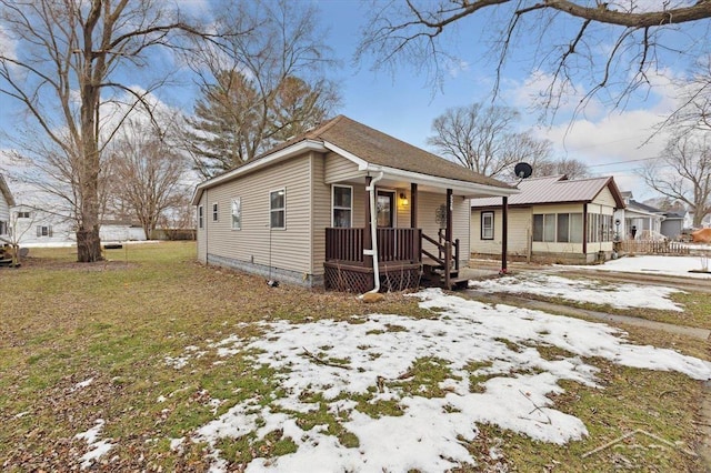 bungalow-style house with a yard and covered porch