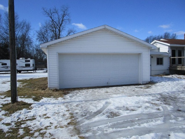 snow covered garage featuring a garage