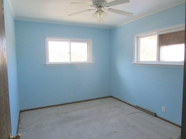 carpeted spare room with crown molding, a healthy amount of sunlight, baseboards, and ceiling fan