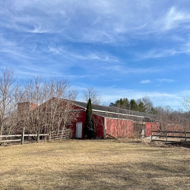 view of yard featuring a pole building, an outdoor structure, and fence