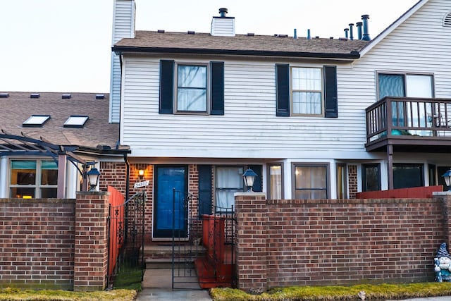 townhome / multi-family property with brick siding and a chimney