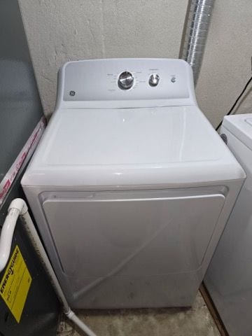 laundry room with laundry area, washer / clothes dryer, and a textured wall