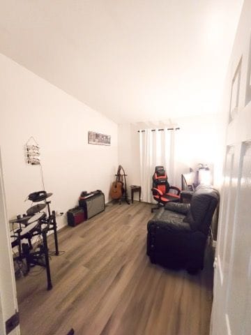 living area featuring lofted ceiling and wood finished floors