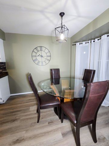 dining area featuring baseboards and light wood finished floors