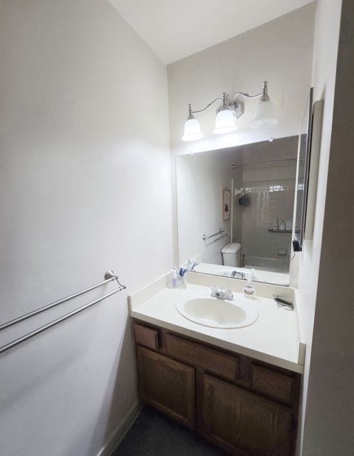 bathroom with toilet, walk in shower, and vanity