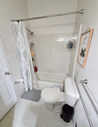 bathroom with tile patterned floors, toilet, and shower / tub combo with curtain