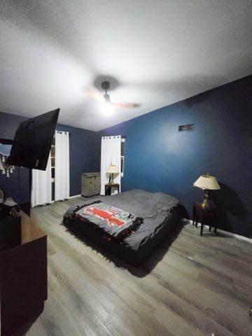 bedroom featuring wood finished floors and a ceiling fan