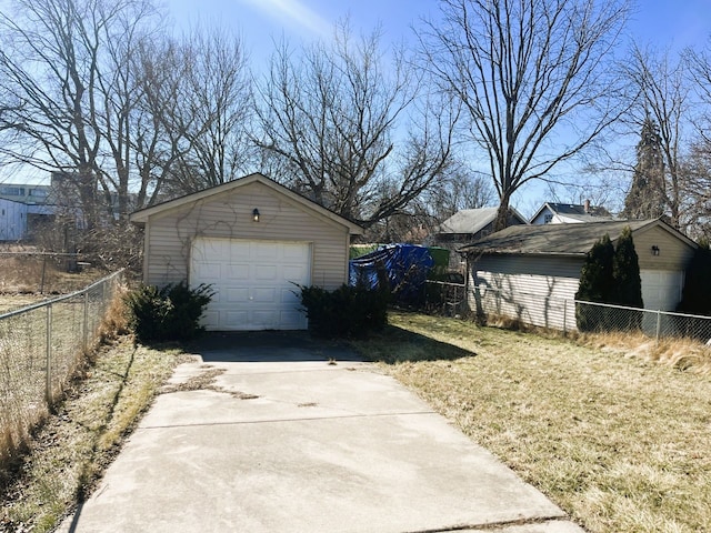 detached garage featuring fence and driveway