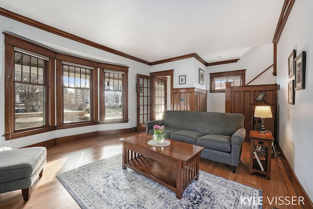 living room featuring crown molding, wood finished floors, and baseboards