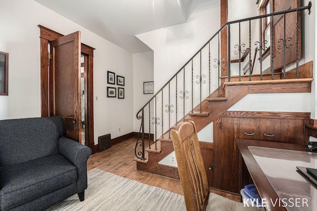 stairs with visible vents, baseboards, and wood finished floors