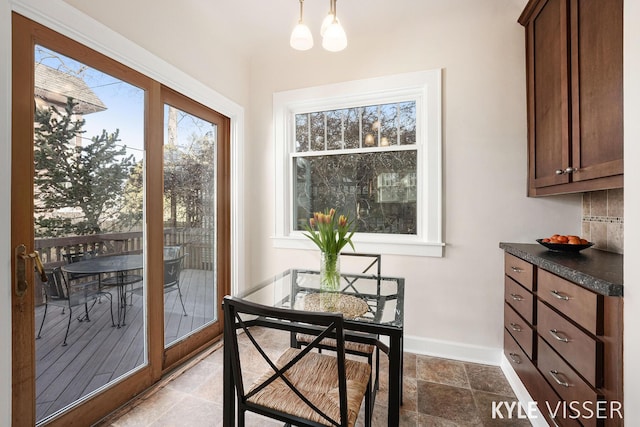 dining room featuring stone finish floor and baseboards