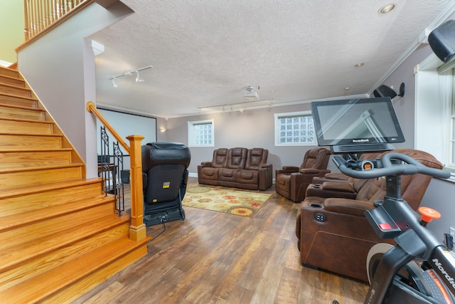 living area featuring ornamental molding, track lighting, a textured ceiling, wood finished floors, and stairway