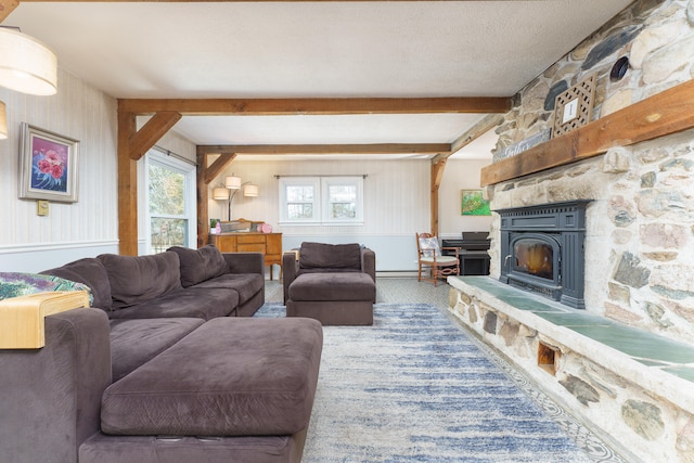 living room with beamed ceiling, a textured ceiling, and a lit fireplace