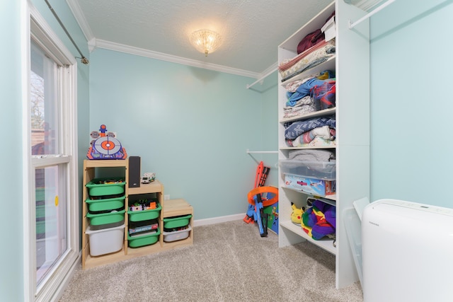 playroom featuring a textured ceiling, crown molding, baseboards, and carpet floors