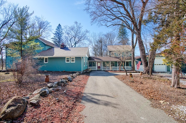 view of front of house featuring aphalt driveway and roof with shingles