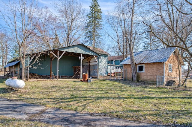 view of front of house featuring a front lawn, fence, metal roof, an outdoor structure, and a pole building