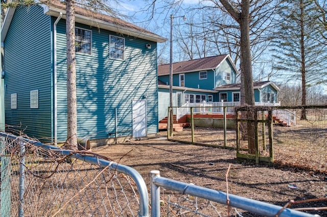 back of property with a wooden deck and fence