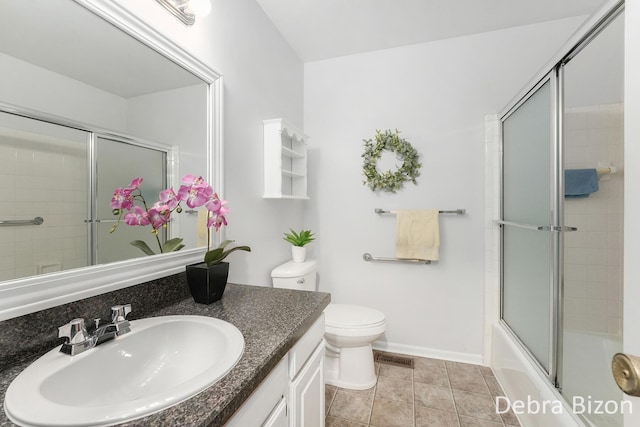 bathroom featuring vanity, visible vents, shower / bath combination with glass door, tile patterned floors, and toilet