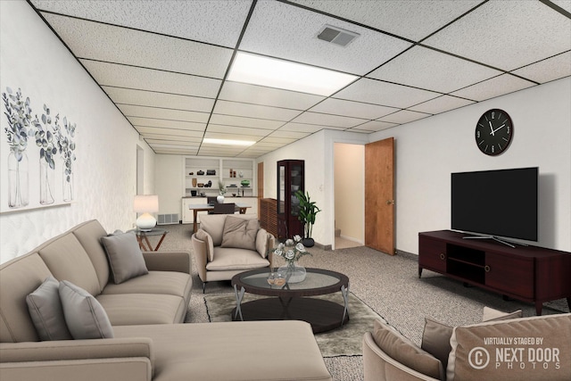 carpeted living area featuring built in features, a paneled ceiling, and visible vents