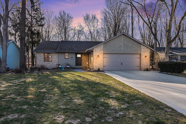 mid-century inspired home featuring a yard, brick siding, a garage, and driveway