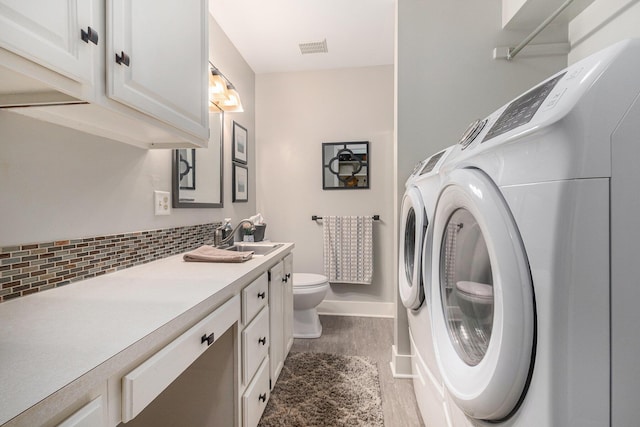 bathroom with visible vents, toilet, washer and clothes dryer, backsplash, and vanity