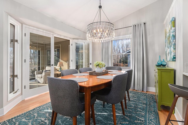 dining area with an inviting chandelier, wood finished floors, baseboards, and french doors