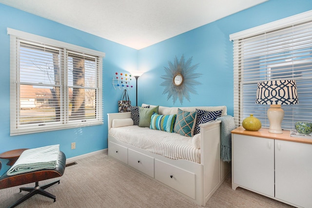 living area featuring baseboards and light carpet