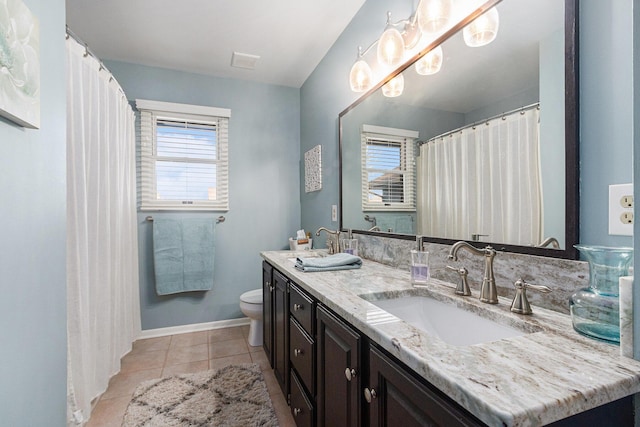 full bath with baseboards, toilet, double vanity, tile patterned floors, and a sink