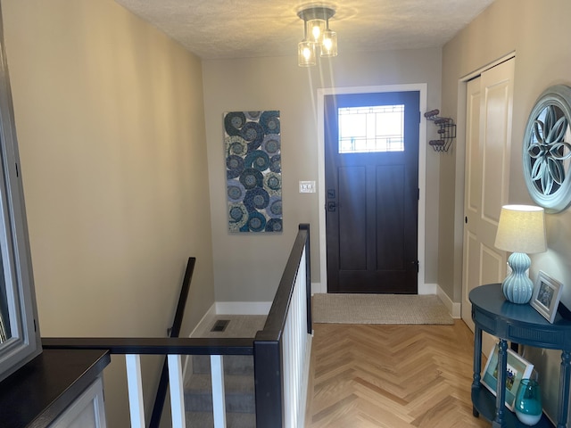 foyer with baseboards and a textured ceiling