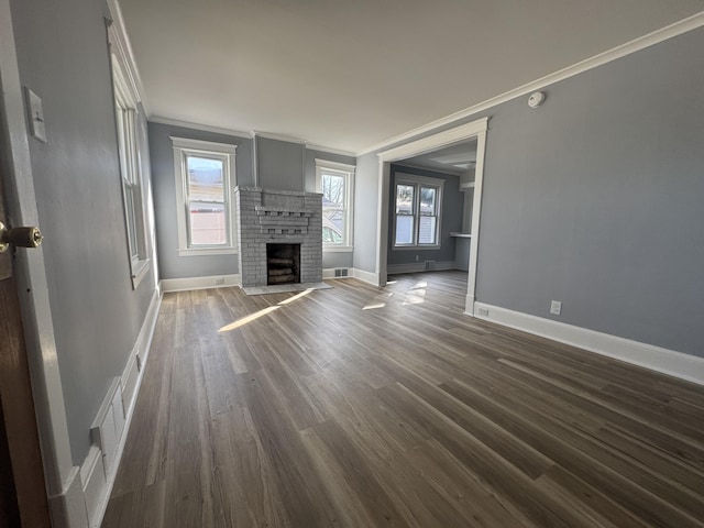 unfurnished living room with dark wood-style floors, a fireplace, baseboards, and ornamental molding