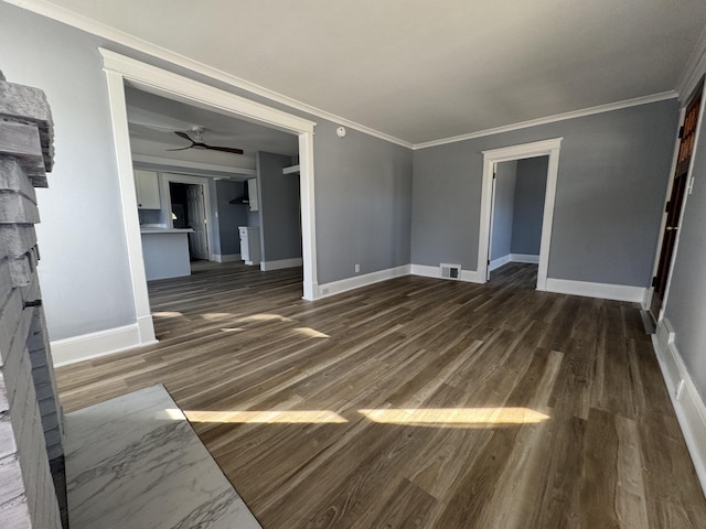 unfurnished living room with visible vents, a stone fireplace, wood finished floors, and crown molding