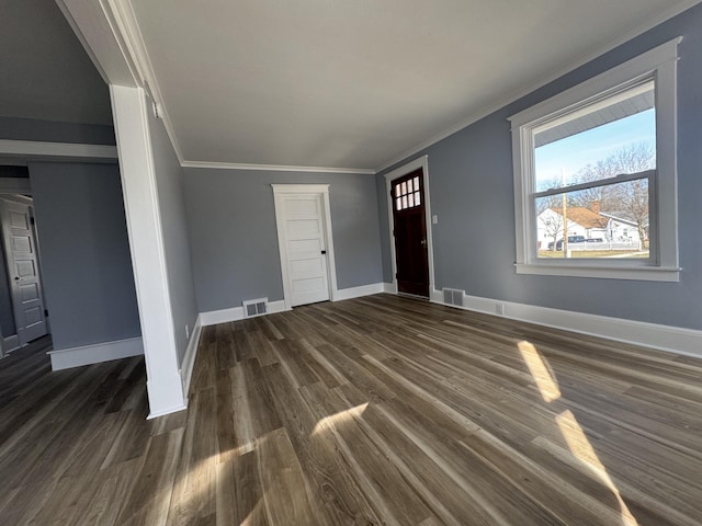 unfurnished living room with crown molding, visible vents, and dark wood-type flooring