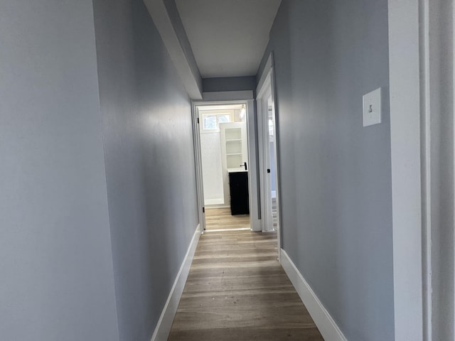 hall featuring dark wood-style floors and baseboards