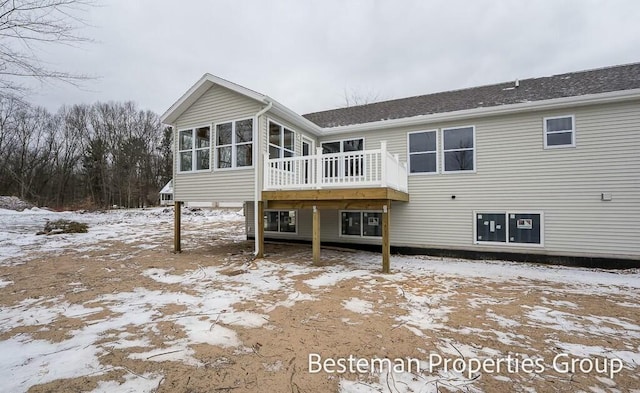 snow covered property featuring a sunroom and a wooden deck