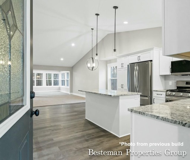 kitchen featuring dark wood-type flooring, a kitchen island, stainless steel appliances, white cabinets, and light stone countertops