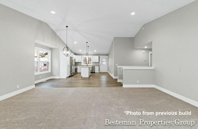 unfurnished living room with dark colored carpet, baseboards, and recessed lighting