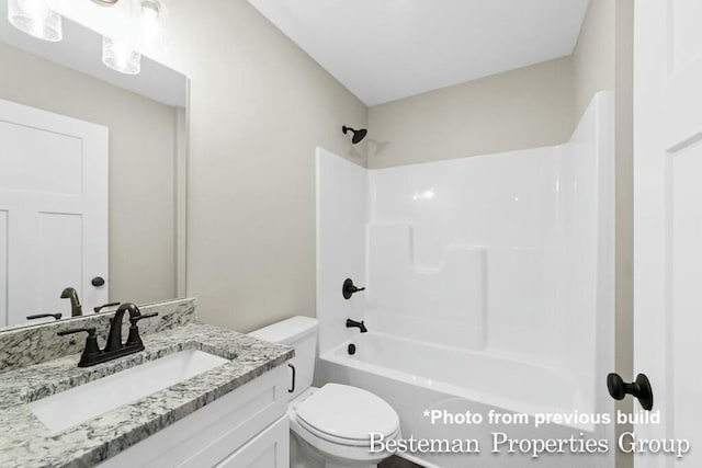 bathroom featuring toilet, vanity, and bathing tub / shower combination