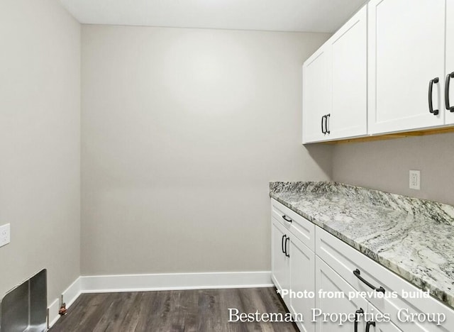 laundry room featuring dark wood-type flooring and baseboards