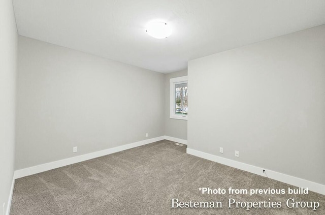 spare room with baseboards and carpet flooring