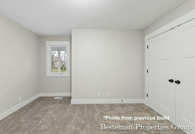 unfurnished bedroom with visible vents, baseboards, and carpet