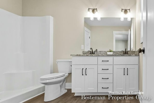 bathroom with walk in shower, toilet, double vanity, wood finished floors, and a sink