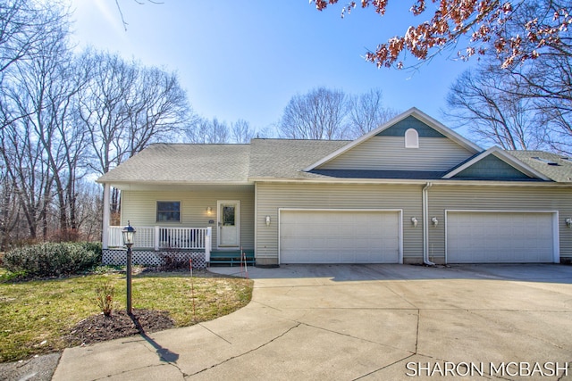 view of front of property with a garage, roof with shingles, covered porch, and driveway