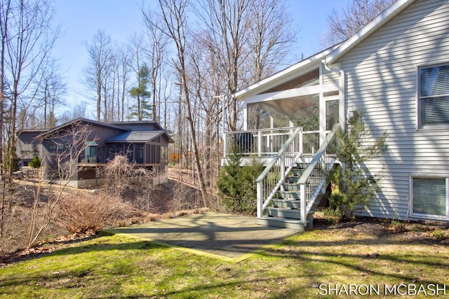 view of yard featuring stairs and a sunroom