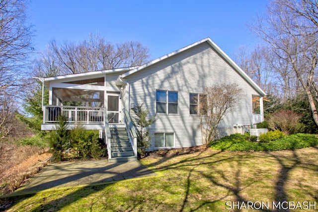 exterior space featuring a yard, stairs, and a sunroom