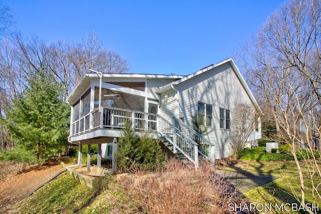 view of side of property featuring stairway and a sunroom