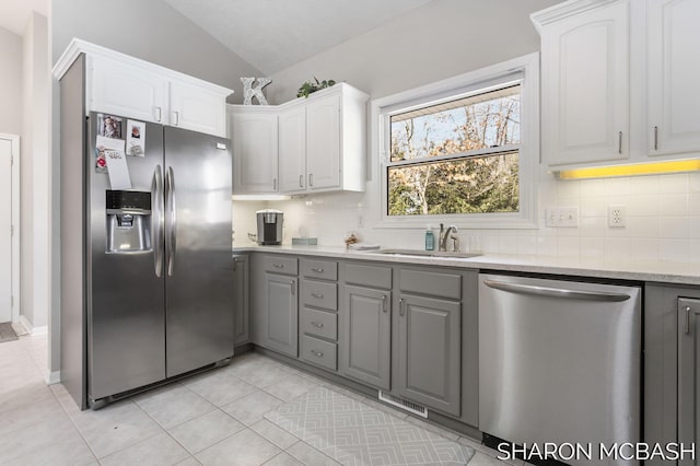 kitchen featuring a sink, decorative backsplash, gray cabinetry, and stainless steel appliances