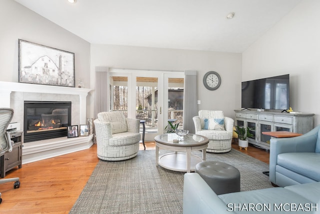 living room with recessed lighting, lofted ceiling, wood finished floors, and a fireplace