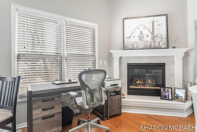 office space featuring wood finished floors and a fireplace