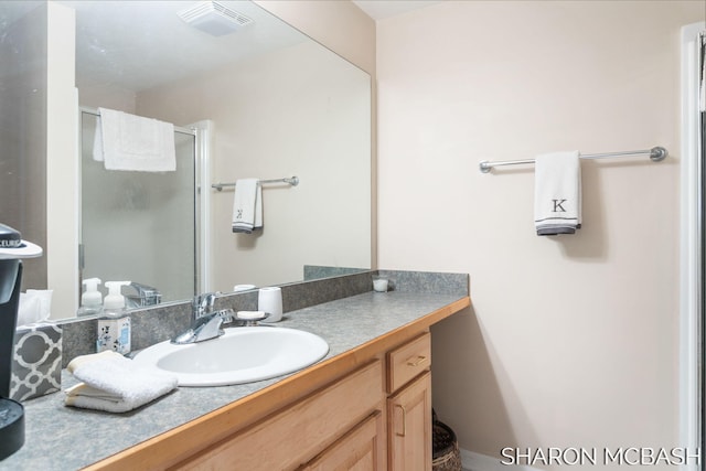 bathroom with vanity, visible vents, and a stall shower