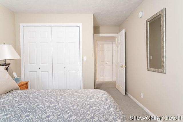 bedroom featuring baseboards, a closet, carpet floors, and a textured ceiling